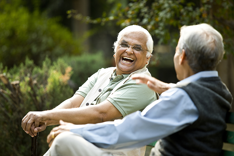 Two elderly gentlemen sitting on park bench